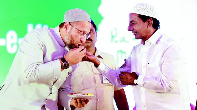 Chief Minister K. Chandrasekhar Rao offers dates to AIMIM president and Hyderabad MP Asaduddin Owaisi at an iftar party organised by the Telangana government at LB stadium in Hyderabad on Friday. (Photo: DC)