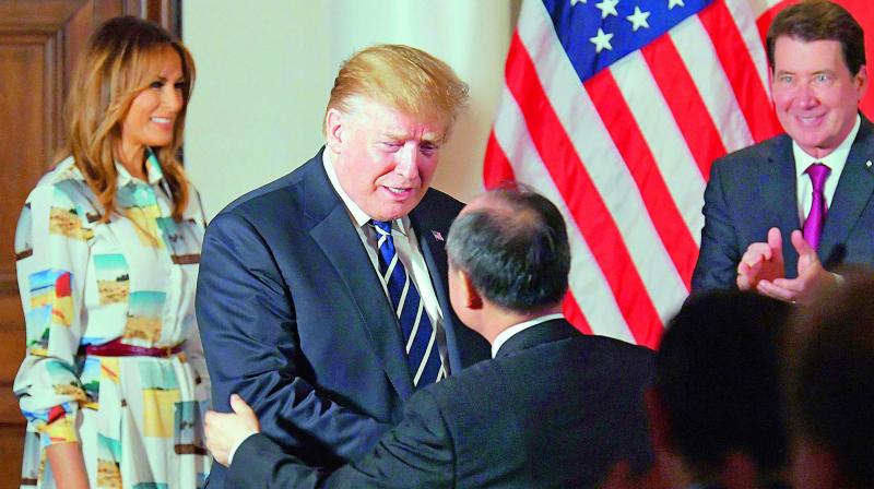 US President Donald Trump greets SoftBank Group Corp. Chief Executive Masayoshi Son as first lady Melania Trump looks on during his meeting with business leaders in Tokyo on Saturday. (Photo: AP)