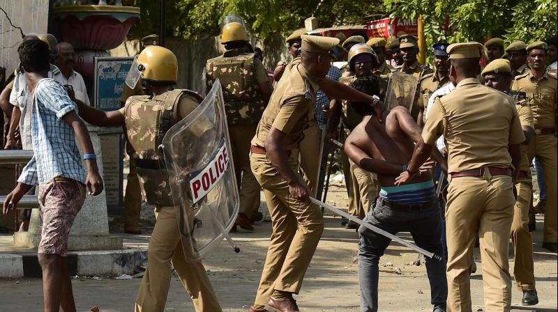 Police lathicharge to disperse protesters during a violent clash with the police near Marina Beach in Chennai on Monday.