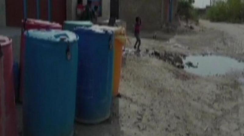 Due to acute shortage of water, there have been cases of water theft at night a couple of times. So, we have decided to put locks in our drums to save our share of water, a local said. (Photo: ANI)