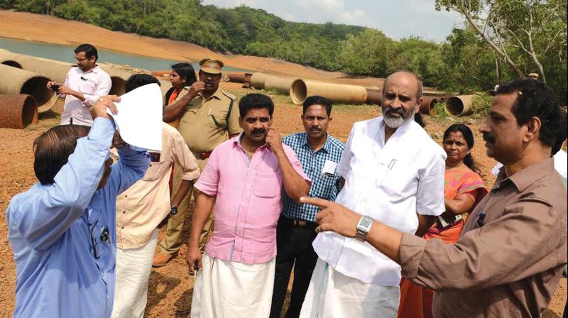 An official explains feasibility of linking Neyyar dam to Aruvikkara reservoir to water resources minister Mathew T. Thomas. Seen behind are pipelines procured for realising the project four decades ago. (Photo: DC)