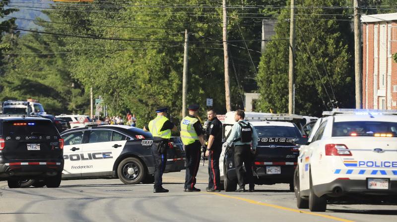 Police officers survey the area of a shooting in Fredericton, New Brunswick, Canada on Friday. (Photo: AP)