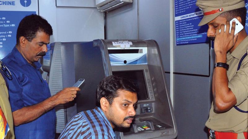 Fingerprint experts and police inspect the SBI ATM that came under attack in Manachira on Thursday. (Photo:  DC)