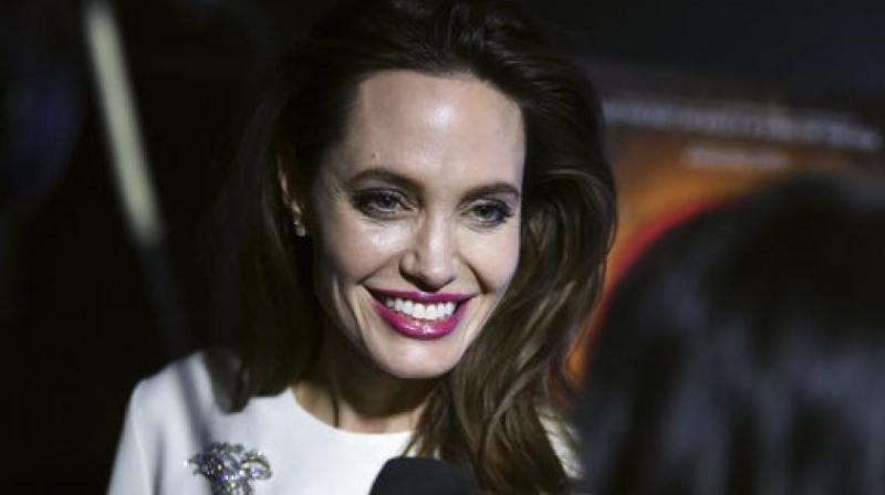 Angelina Jolie tries \not to cry\ as she drops son to college