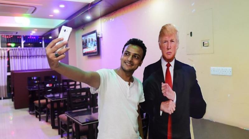 Politics appears to be last thing on many diners minds as they pose for photos with a cardboard cutout of the US president, placed strategically at the entrance by 29-year-old businessman Islam. (Photo: AFP)