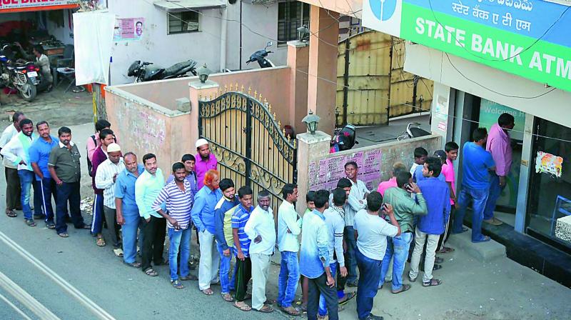 People stand in queue to withdraw cash from an ATM at Ramanthapur in Hyderabad on Wednesday. 	(Photo: Deepak Deshpande)