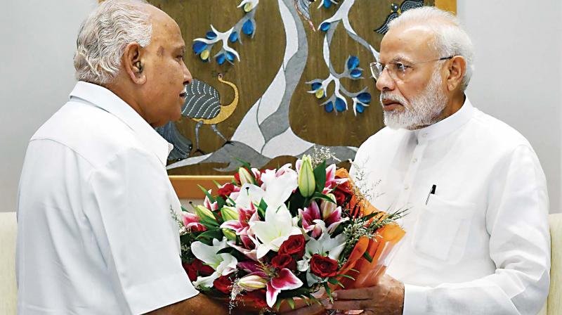 Prime Minister Narendra Modi is presented a bouquet by Karnataka Chief Minister BS Yediyurappa during a meeting, in New Delhi, Friday.