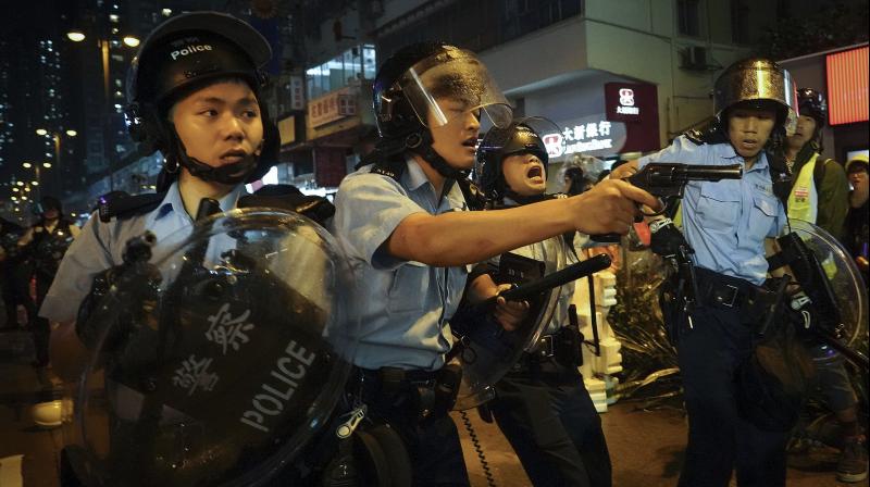 As protest enters 12th week, Hong Kong police draw guns, arrest 36
