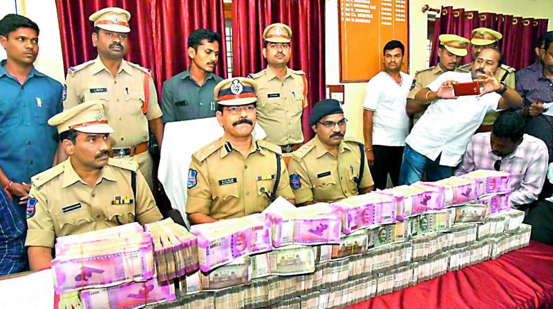 Police officials display the cash seized from a car at Pembarti in Jangaon district on Tuesday.