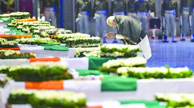 Prime Minister Narendra Modi pays tribute to the martyred CRPF jawans who lost their lives in Thursdays Pulwama terror attack after their mortal remains were brought to Air Force Station Palam in New Delhi. (Photo: PTI)