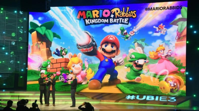 Ubisoft CEO Yves Guillemot (R) and game designer and producer Shigeru Miyamoto (C) introduce \Mario + Rabbits, Kingdom Battle\ to the audience at the Ubisoft E3 Conference in Los Angeles, California on June 12, 2017. (Photo: AFP)