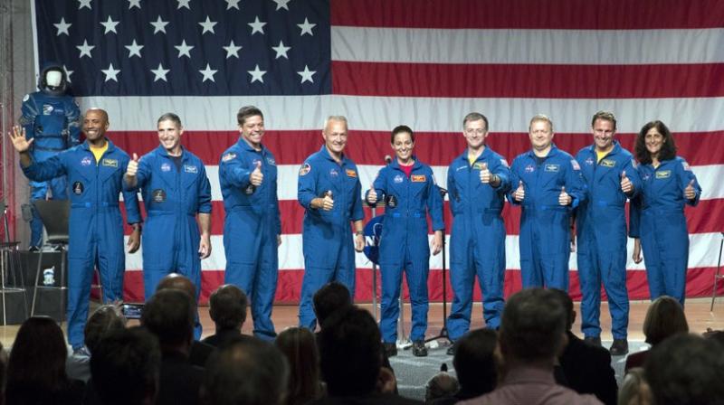 Astronauts, left to right, Victor Glover, Michael Hopkins, Robert Behnken, Douglas Hurley, Nicole Mann, Christopher Ferguson, Eric Boe, Josh Cassada and Sunita Williams give a thumbs up to the crowd after NASA announced them as astronauts assigned to crew the first flight tests and missions of the Boeing CST-100 Starliner and SpaceX Crew Dragon.  (AP Photo/David J. Phillip)