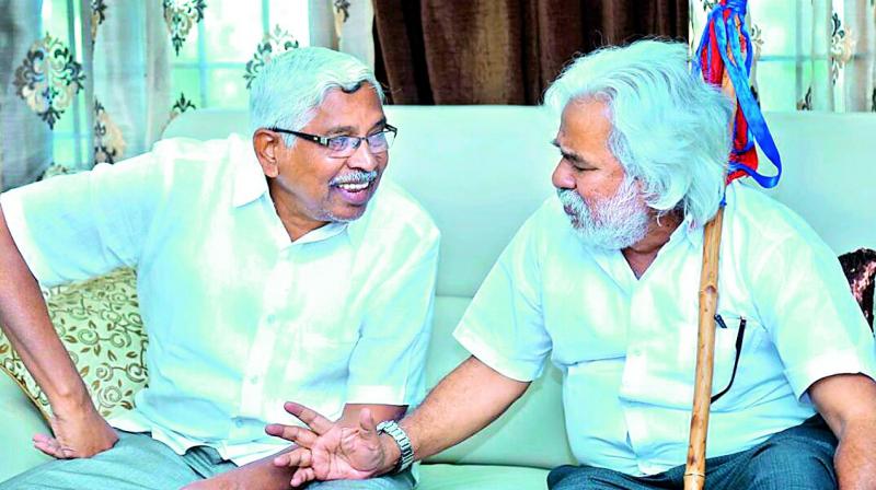 Telangana Jana Samiti president and Mahakutami convenor Kodandaram along withballadeer Gaddar at a meeting on Monday.