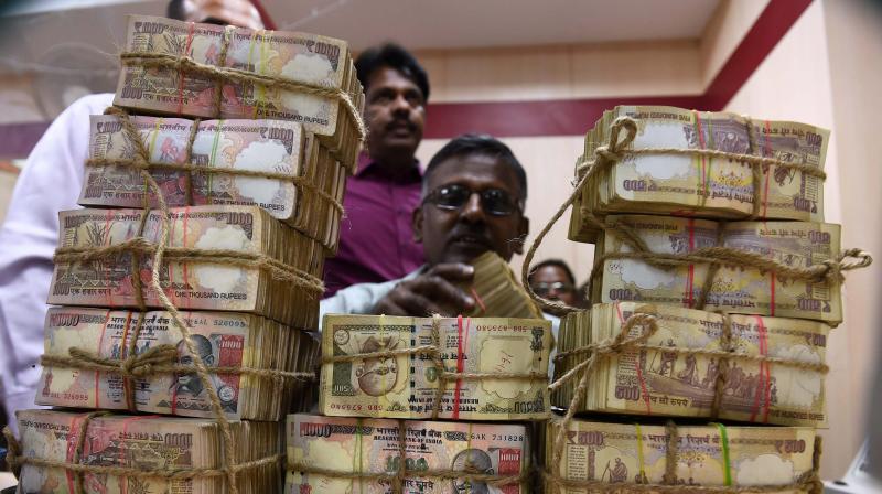 A bank employee counting the bundles of the received currency of old Rs 1000 and 500 notes at cash counter at a Punjab National Bank branch in Chennai. (Photo: PTI)
