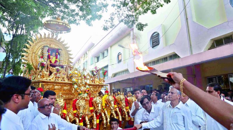 Devotees take out a procession of Sathya Sais portrait on a golden chariot.