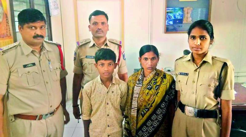 Kidnapped student Rakesh Varma, his mother Rukmini Devi and Mailardevpally police inspector  K. Sataiah Goud and his colleagues pose for a photo after the boy was reunited with his mother.