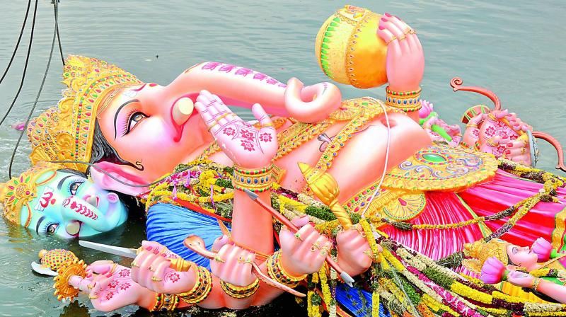 The 57-foot tall Khairtabad Lord Ganesha sinks into the water after its immersion in Tank Bund.   Image: Deepak Deshpande