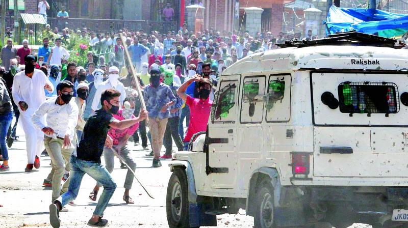 Youths damage a police jeep as they clash during their protest against the arrest of students and killing of Hizbul Mujahideen commander Sabzar Bhat, in Srinagar on Friday. (Photo: PTI)