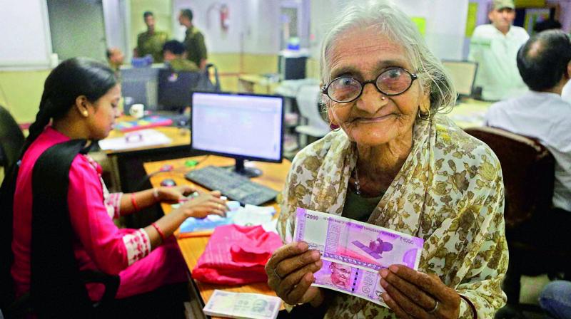An 85-year-old woman with the new Rs 2,000 currency notes she received at a bank on Sunday. (Photo: PTI)