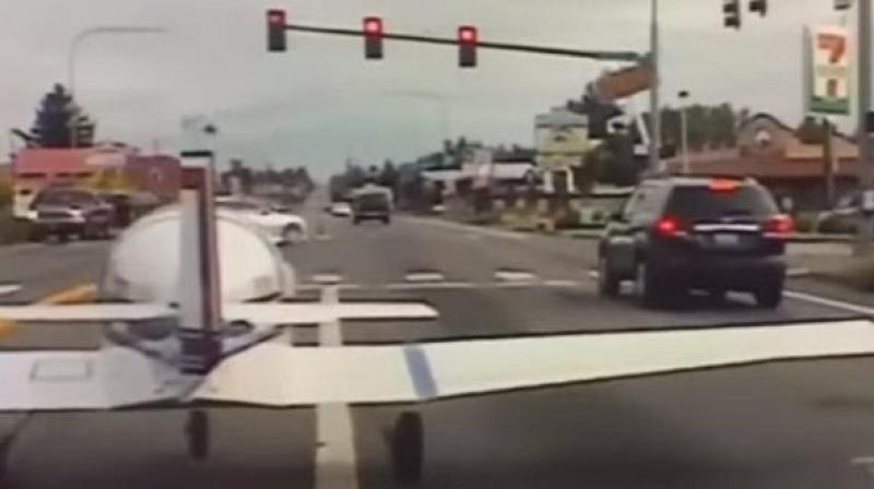 Small airplane lands on busy highway; halts before red light as police dashcam rolls