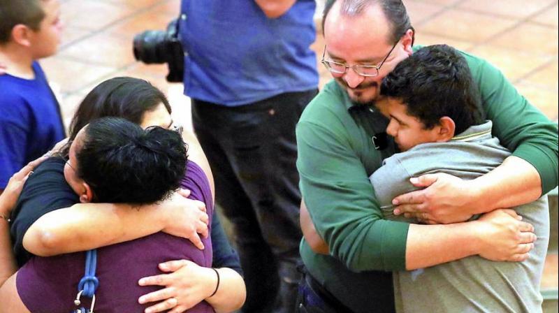 People hug at St Pius X Church at a vigil for victims after a mass shooting which left at least 20 people dead on Sunday in El Paso, Texas. (Photo: AFP)