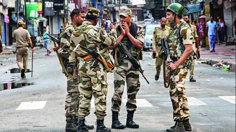 Security personnel stand guard during restrictions in Jammu on Monday. Restrictions and night curfews were imposed in several districts of Jammu and Kashmir as the Valley remained on edge with the authorities stepping up security deployment. (Photo: PTI)