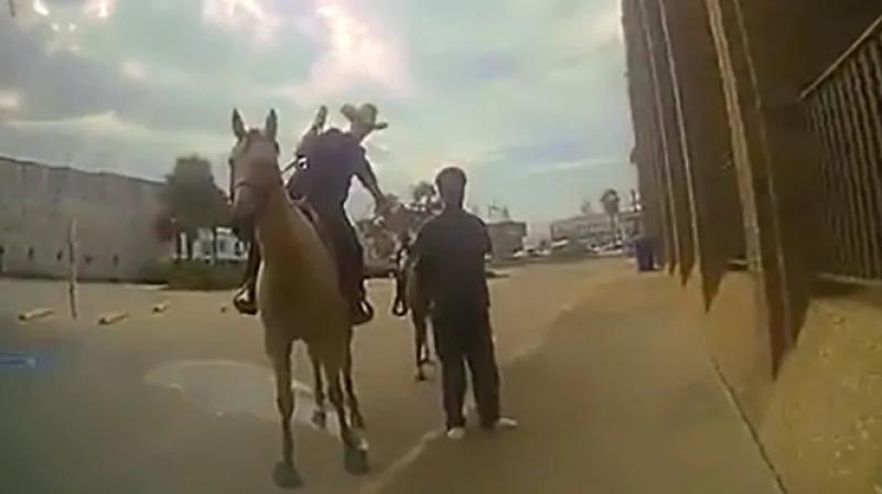 \Stay next to me\: US cop, on horseback, leads black man tied to rope; see video