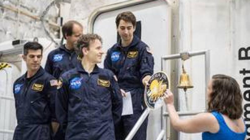 Moments after turning the vessel back over to NASA after 45-days inside, the HERA XIII crew is given their mission patch to place on the door. Credits: NASA