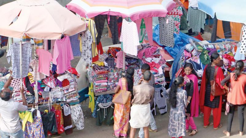 Seasonal street vendors busy selling cloths at SM Street, Kozhikode on Friday.  (DC)