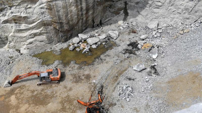 A scene from the sport where the the quarry accident happened at Kunnathukal near Parassala in Thiruvananthapuram on Friday. The excavator crushed by the granite mount can be seen (Photo: DC)