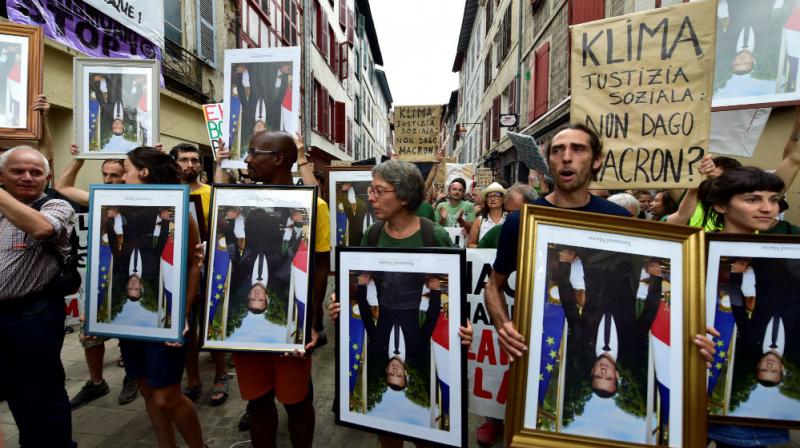 Anti-G7 protesters march with \stolen\ portraits of Emmanuel Macron