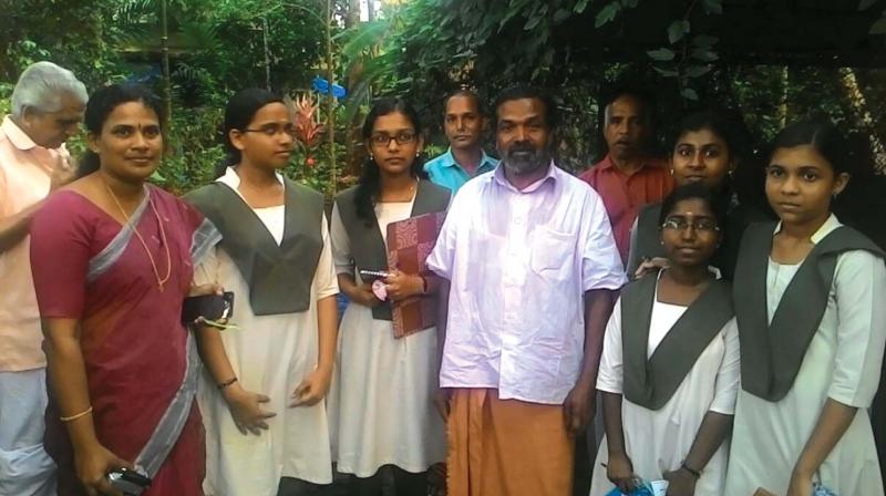 Students of GHSS Kokkallur with traditional farmer Cheruvayal Raman and teacher Sindhu E.S at Kottanada Vayal.