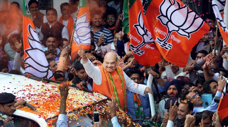 BJP President Amit Shah waves at party workers who welcome him on his arrival at the party headquarters after partys win in Uttar Pradesh and Uttarakhand Assembly elections, in New Delhi on Saturday. (Photo: PTI)