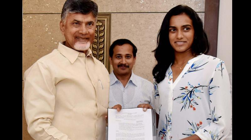 Andhra Pradesh Chief Minister N Chandrababu Naidu handing over letter of appointment to as Group I officer to ace shuttlers PV Sindhu in Vijayawada. (Photo: PTI)