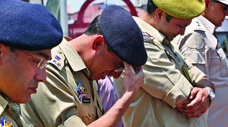 A police officer weeps near the coffin of colleague Arsheed Ahmad as he pays homage to Ahmad during a wreath laying ceremony in Srinagar on Monday. Police inspector Ahmad, who was critically injured in a militant attack in J&Ks Anantnag district on June 12, had succumbed to his injuries on Sunday afternoon at the All India Institute of Medical Sciences in New Delhi.	(AP)