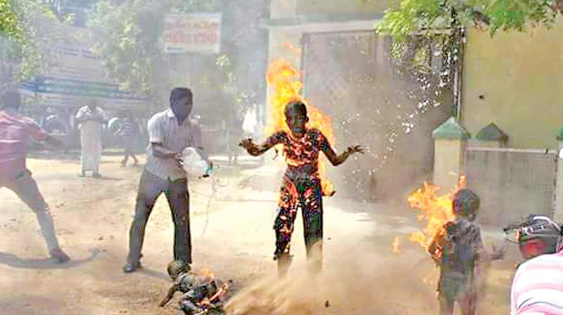 Public attempt to douse the fire on people who immolated themselves at the District Collectors office in Tirunelveli on Monday. (Photo: DC)