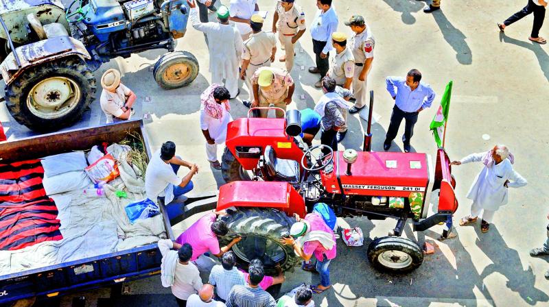 Farmers repair their tractors after ending Kisan Kranti Padyatra at NH24 on Delhi-UP border on Tuesday. (Photo:PTI)