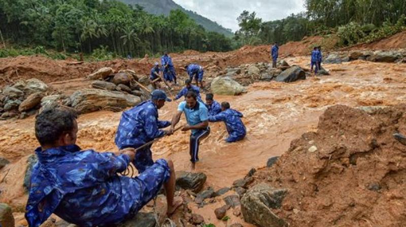 Rescue workers search for the bodies of missing persons after a landslide, triggered by heavy rains and floods, at Nenmara in Palakkad. (Photo: PTI)