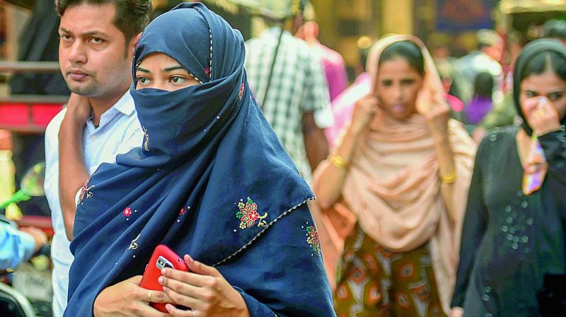 A Muslim woman walking in a market, near Jama Masjid in New Delhi on Wednesday.  (Photo:PTI)
