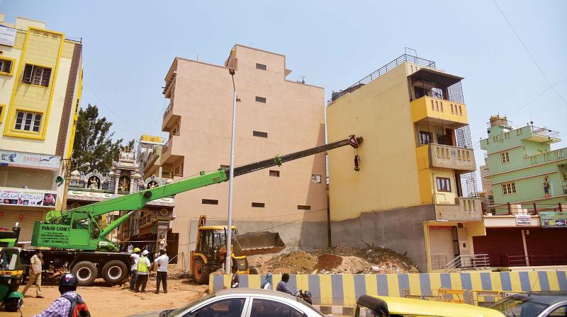 A crane being used on Wednesday to straighten a three-storeyed house that had begun to tilt at Horamavu in Bengaluru from Sunday
