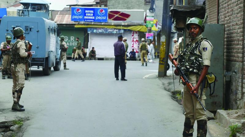 Security personnel stand guard during restrictions at Downtown in Srinagar on Saturday (Photo: AP)
