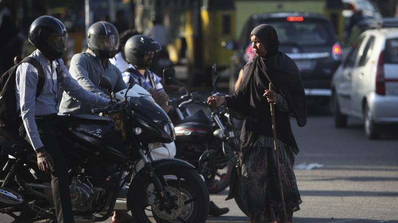 An Indian woman asks for alms at a traffic intersection in Hyderabad. (Photo: AP)