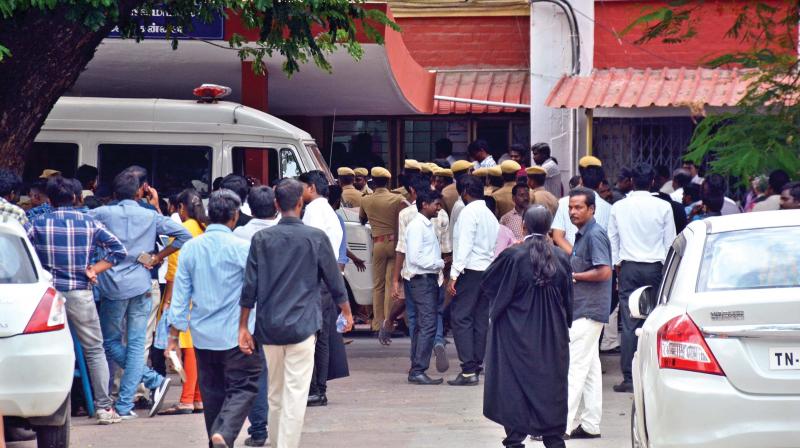 Lawyers, police personnel wait outside the Mahila Court on Madras High Court premises, on Tuesday (Photo: DC)