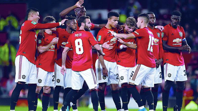 Manchester United players celebrate their win over Rochdale in their League Cup third round match at Old Trafford on Wednesday. (Photo: AP)
