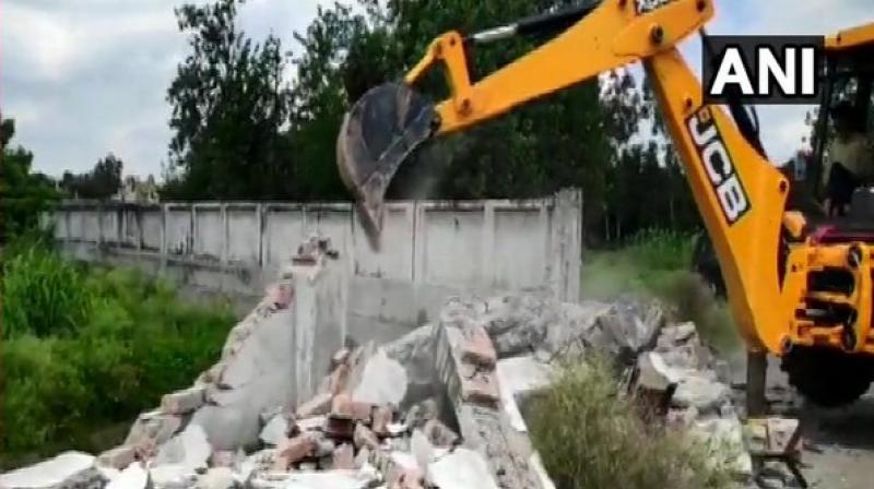 The irrigation department along with the district administration demolished the wall today which was erected illegally, official said. (Photo: ANI)