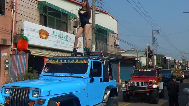 Pole dancers perform on top of jeeps during the funeral procession of former Chiayi City county council speaker Tung Hsiang in Chiayi City, southern Taiwan on January 3, 2017. (Photo: AFP)