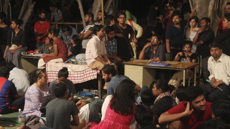 Students wait in front of a counting centre in JNU campus on Saturday. (Photo: PTI)