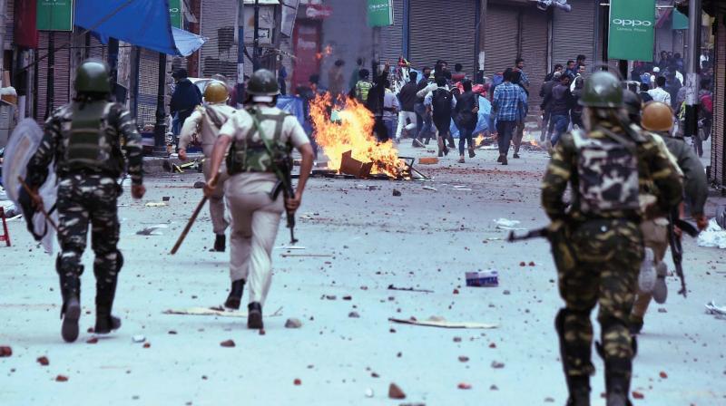 Police and CRPF in action against students throw stones on them during clashes in the vicinity of Lal Chowk in Srinagar on Monday. (Photo: PTI)