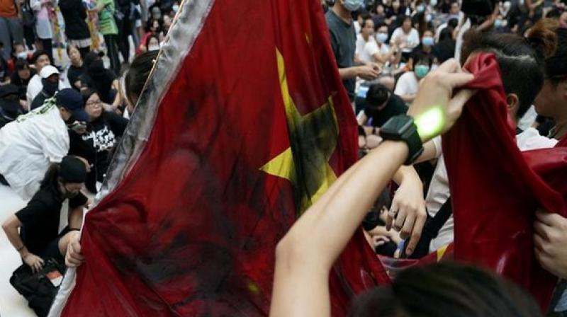 Hong Kong protestors trample Chinese national flag, throw it into river