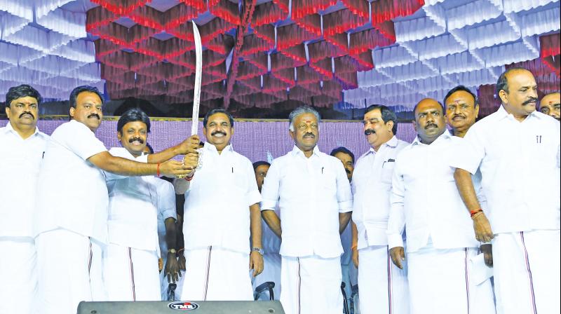 Chief Minister Edappadi K. Palaniswami presented with a sliver sword at a function in Tenkasi where AMMK cadres rejoined AIADMK. Deputy CM O. Panneerselvam and other AIADMK seniors including Manoj Pandian were also present. (Photo: DC)